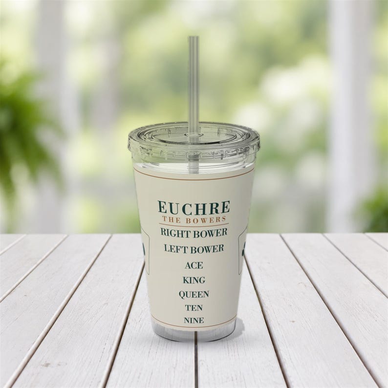 May include: A clear plastic tumbler with a lid and straw featuring a cream-coloured label printed with the text EUCHRE THE BOWERS, RIGHT BOWER, LEFT BOWER, ACE, KING, QUEEN, TEN, NINE in dark green and brown lettering on the front surface.