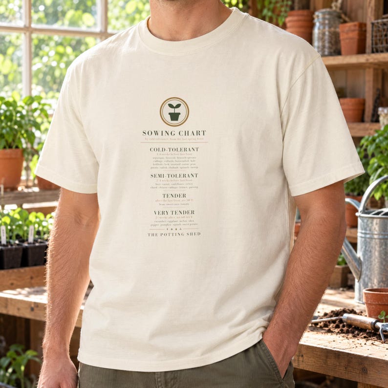 Puede incluir: Una camiseta de manga corta color hueso con un gr&aacute;fico verde oscuro de una pl&aacute;ntula en una maceta sobre el texto SOWING CHART. El dise&ntilde;o incluye categor&iacute;as para plantas tolerantes al fr&iacute;o, semi-tolerantes, tiernas y muy tiernas.