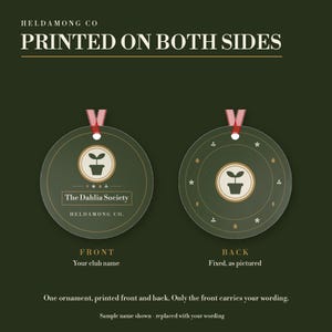May include: Two round dark green ornaments with red ribbons. The front features a potted plant icon, the text 'The Dahlia Society' and 'HELDAMONG CO.' The back displays a potted plant icon surrounded by small symbols. Text reads 'PRINTED ON BOTH SIDES'.