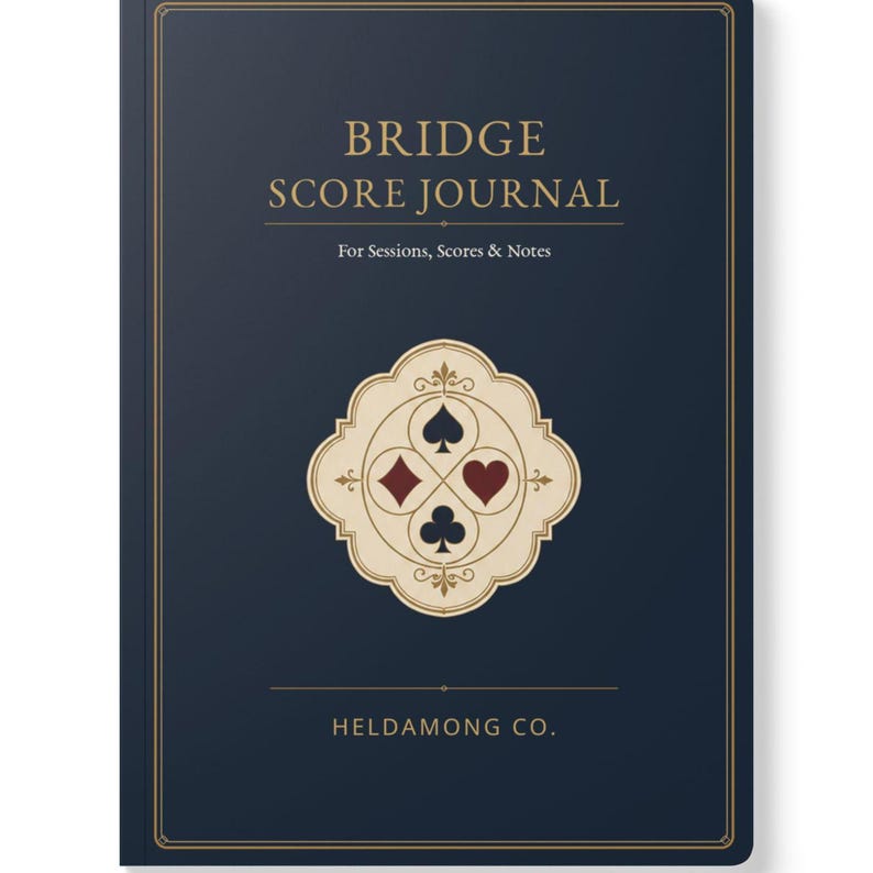 May include: A dark blue journal with gold text reading BRIDGE SCORE JOURNAL For Sessions, Scores & Notes and HELDAMONG CO. at the bottom. The centre features a cream-coloured decorative emblem containing the four card suit symbols in black and red.