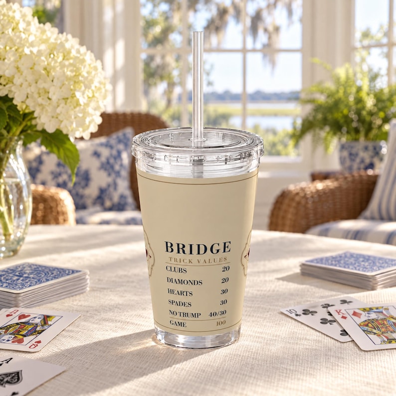 以下が含まれることがあります： ストローと蓋が付いた透明なプラスチック製タンブラー。ベージュのラップには「BRIDGE TRICK VALUES」という文字と、Clubs、Diamonds、Hearts、Spades、No Trump、Gameといったカードのスートとそれぞれのポイント値が記載されています。