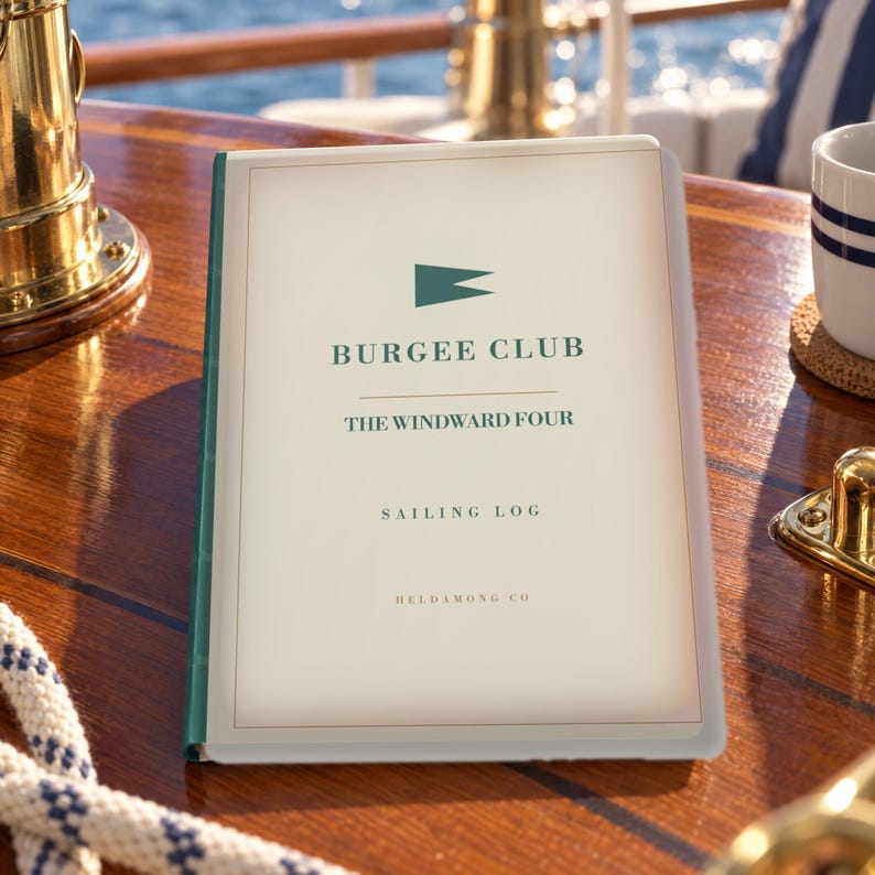 May include: A rectangular sailing log book with a cream-coloured cover featuring a dark green burgee flag icon, the text BURGEE CLUB, THE WINDWARD FOUR, SAILING LOG, and HELDAMONG CO in dark green lettering, with a dark green spine.