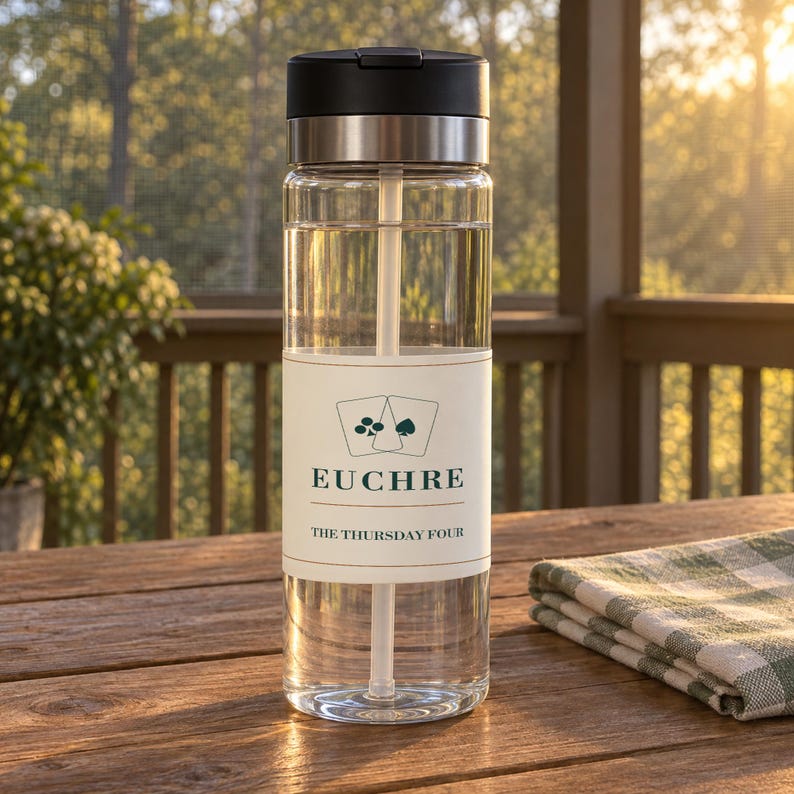 May include: A clear plastic water bottle with a black lid and a built-in straw. The bottle features a white label with a graphic of two playing cards, the word EUCHRE in green text, and the phrase THE THURSDAY FOUR printed in smaller black text.