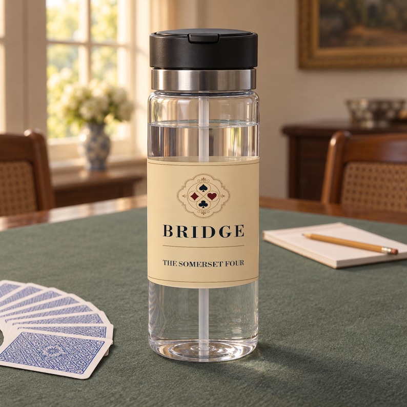May include: A clear plastic water bottle with a black lid and a straw. The bottle features a beige label with the text BRIDGE and THE SOMERSET FOUR, along with a graphic of four playing card suits arranged in a diamond pattern on the front.