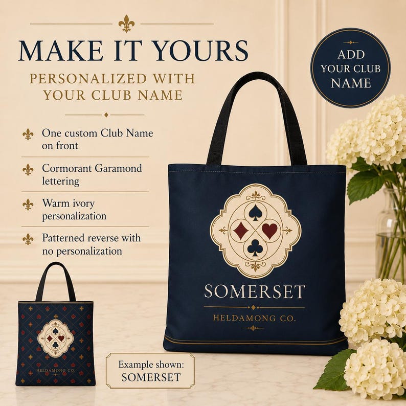 May include: A navy blue tote bag featuring a central cream-coloured emblem with four playing card suit symbols in red and black. The text SOMERSET and HELDAMONG CO. is printed in warm ivory. The reverse side displays a repeating pattern of suits.