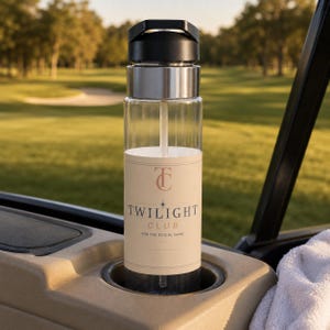 May include: A clear water bottle with a black lid and a straw, featuring a beige label with the text "TC TWILIGHT CLUB FOR THE SOCIAL GAME" in dark lettering. The bottle is cylindrical with a metallic silver band below the black cap.