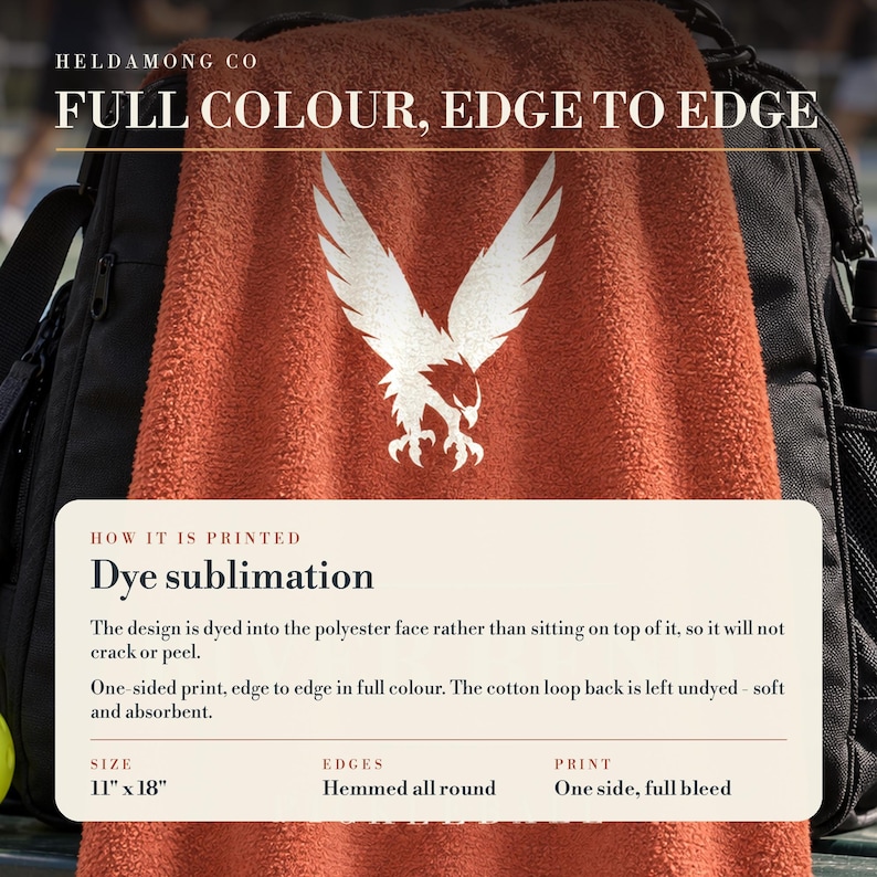 May include: A rust-orange towel featuring a white eagle graphic. Text reads: HELDAMONG CO FULL COLOUR, EDGE TO EDGE. A box details dye sublimation printing, noting a polyester face, cotton loop back, 11" x 18" size, and hemmed edges.