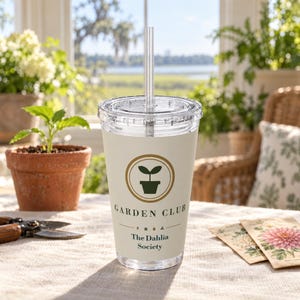May include: A clear plastic tumbler with a lid and straw, featuring a beige wrap with a dark green potted plant icon inside a gold circle. The text reads GARDEN CLUB, followed by small botanical icons and the words The Dahlia Society in dark blue.