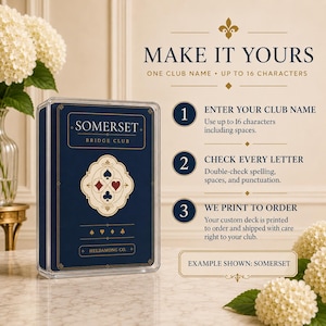 Puede incluir: Una baraja de cartas personalizada en una caja de pl&aacute;stico transparente. La caja azul oscuro presenta texto dorado que dice SOMERSET BRIDGE CLUB y HELDAMONG CO., con un emblema central de los cuatro palos. Las instrucciones explican el proceso.