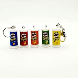 May include: Five miniature Pringles can keychains in different colors: blue, red, orange, green, and yellow. Each keychain features the Pringles logo and mascot.
