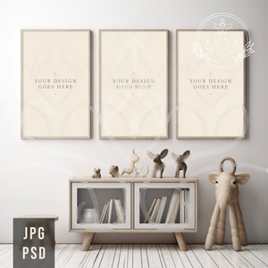May include: Three beige framed prints with the text "YOUR DESIGN GOES HERE" hanging on a white wall above a wooden cabinet with glass doors. The cabinet is filled with books and has a small stool in front of it. There are wooden animal figurines on top of the cabinet.