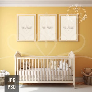 May include: A white cot with a white mattress and a white blanket. There are three framed pictures on the wall behind the cot. The pictures have gold frames and the text "YOUR DESIGN GOES HERE" is printed on each picture. The wall is painted a light yellow colour.