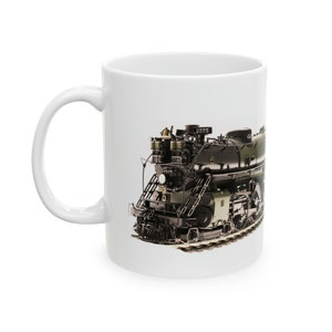 Peut inclure: Une tasse en céramique blanche avec un motif imprimé d'une locomotive à vapeur noire et verte. La locomotive est étiquetée "2575".