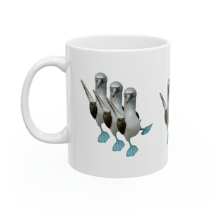 May include: White ceramic mug featuring a repeating pattern of blue-footed boobies. The birds are depicted with their distinctive blue feet and are in a walking pose. The mug has a curved handle and a glossy finish.