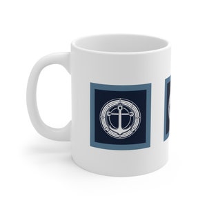 Puede incluir: Taza de cerámica blanca con un diseño náutico. La taza presenta un ancla azul y blanca dentro de un círculo con un diseño de cuerda. El ancla está rodeada de un cuadrado azul con un borde blanco.