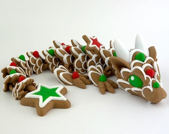 May include: A whimsical, brown gingerbread dragon with white icing details, red and green accents, and a green star-shaped cookie. The dragon's head features white horns and green eyes. A festive, decorative item.