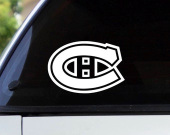 Puede incluir: Calcomanía de vinilo blanco del logotipo del equipo de hockey de los Canadiens de Montreal. El logotipo es una "C" estilizada con una línea horizontal en el centro y dos círculos más pequeños a cada lado de la línea.