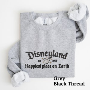 May include: Grey sweatshirt with black thread embroidery that reads "Disneyland est. 1955 Happiest place on Earth".