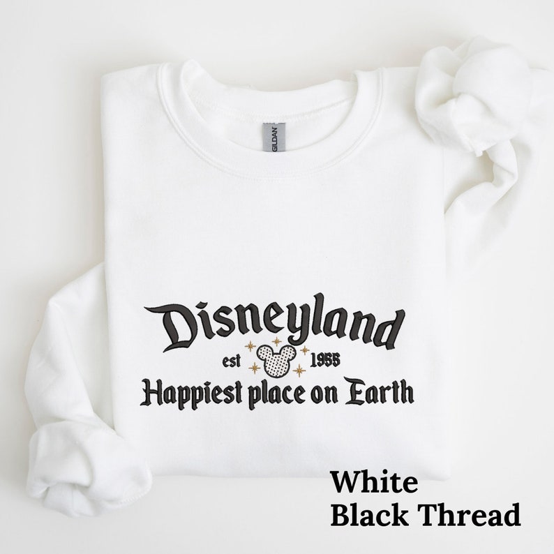 May include: White sweatshirt with black text that reads "Disneyland est. 1955 Happiest place on Earth" with a black and white Mickey Mouse head graphic. The text "White Black Thread" is printed in black at the bottom of the image.