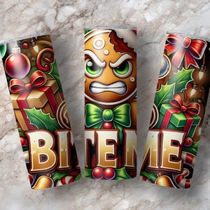 May include: Three stainless steel insulated tumblers with a Christmas theme. Each tumbler features a design with the text "BITE ME". One tumbler has an angry gingerbread man, and the others have holiday decorations.