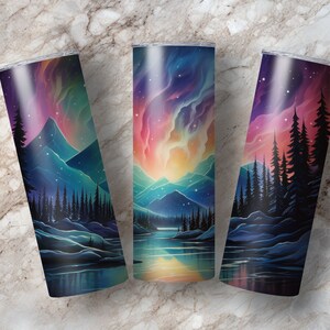 Puede incluir: Tres vasos de acero inoxidable con una escena colorida de aurora boreal sobre una cordillera y un lago. La escena est&aacute; pintada en tonos de azul, morado, rosa y amarillo.