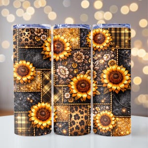 May include: Three stainless steel tumblers with a sunflower theme. Each tumbler features a patchwork design with sunflowers, leopard print, plaid, and floral patterns in shades of gold, brown, and black. The tumblers have a clear lid.
