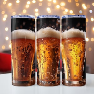 Könnte beinhalten: Drei Edelstahlbecher mit schwarzem Hintergrund und einer Nahaufnahme eines Glases Bier mit Schaum obenauf.