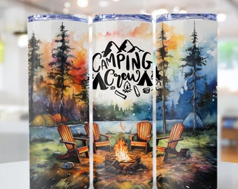May include: Three stainless steel tumblers with a watercolor design of a campsite with a campfire, trees, and a lake. The middle tumbler has the text "Camping Crew" in black lettering.