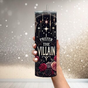 May include: A black stainless steel tumbler with a gold design and the text "I prefer the villain". The design features stars, roses, and a stylized symbol.