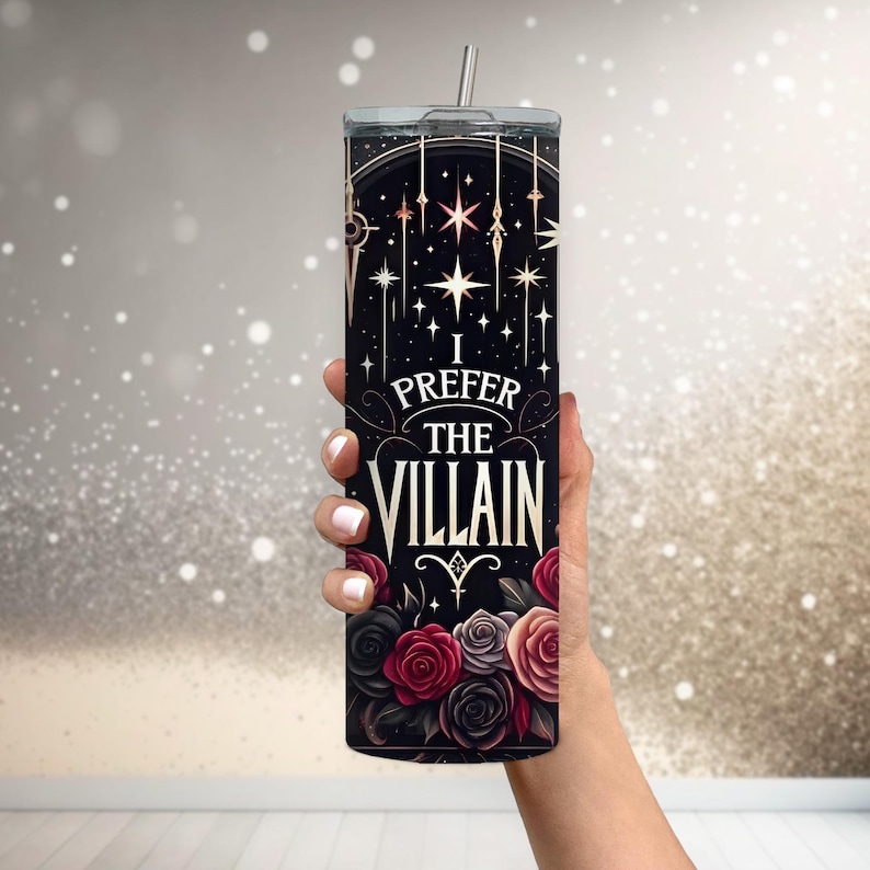 May include: A black stainless steel tumbler with a gold design and the text "I prefer the villain". The design features stars, roses, and a stylized symbol.