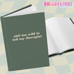 May include: A green journal with the text "shit too wild to tell my therapist" in a retro font. The journal is open to reveal lined pages.
