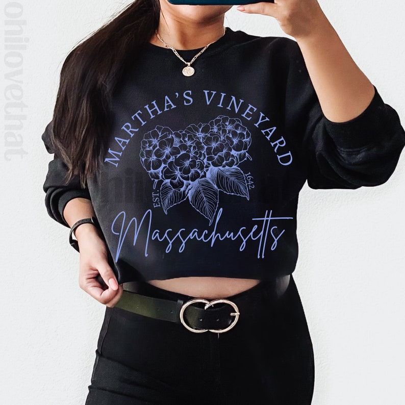 May include: A black cropped sweatshirt with a blue graphic design featuring the text "Martha's Vineyard Est. 1642 Massachusetts" and a floral design.