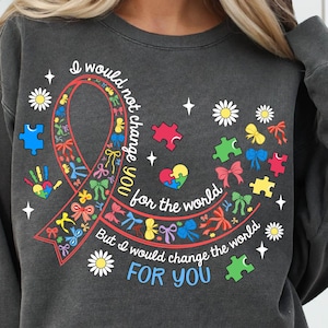 May include: A gray sweatshirt with a colorful ribbon design and the text "I would not change you for the world, but I would change the world for you".