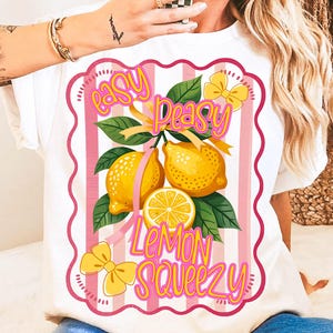 Może przedstawiać: Biała koszulka z różowo-białym paskowanym wzorem z cytrynami i tekstem "Easy Peasy Lemon Squeezy".