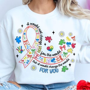 May include: White sweatshirt with a colorful ribbon design and the text "I would not change you for the world, but I would change the world for you".