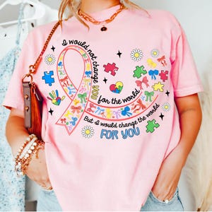 May include: Pink t-shirt with a colorful ribbon design and the text "I would not change you for the world, but I would change the world for you".
