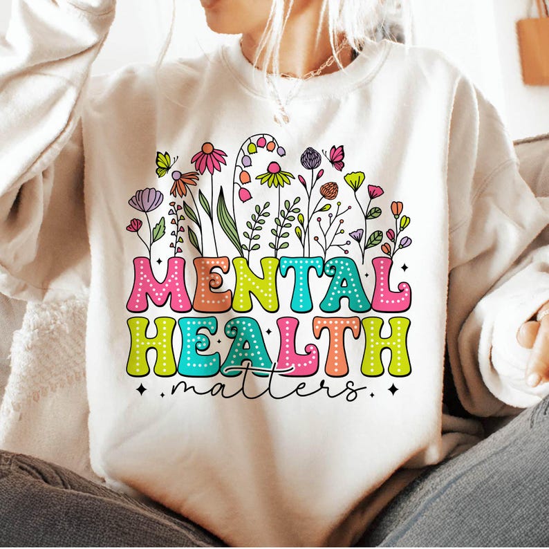 May include: A white sweatshirt with a colorful graphic design featuring flowers and the text "Mental Health Matters".
