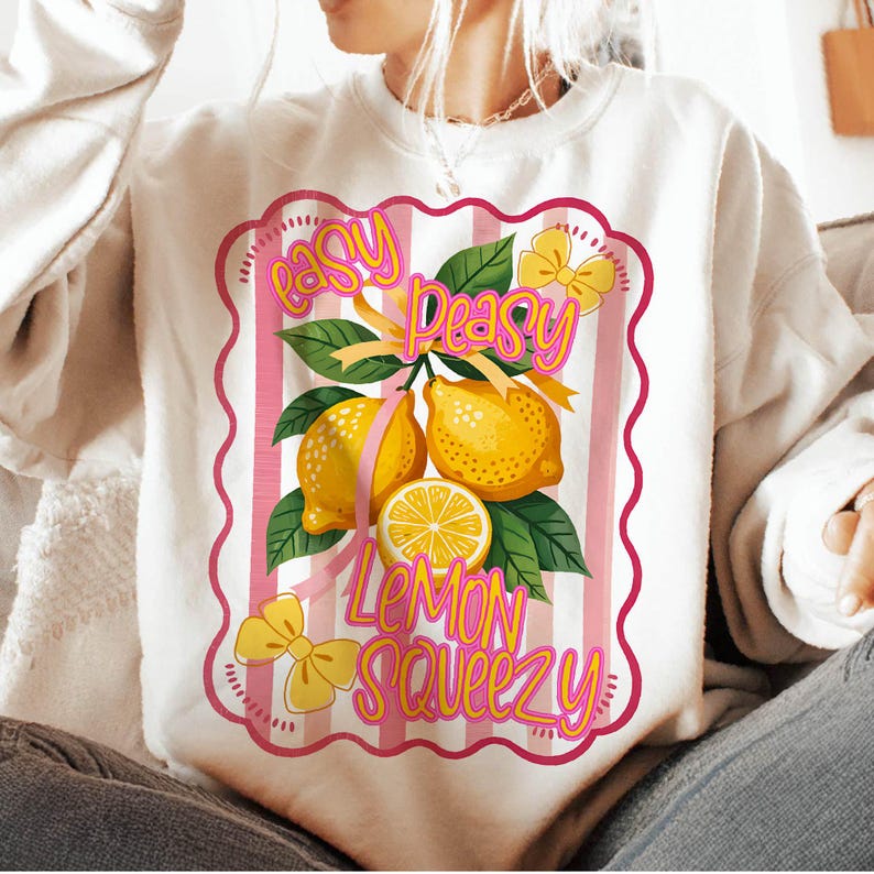 Peut inclure: Sweat-shirt blanc avec un motif ray&eacute; rose et blanc repr&eacute;sentant des citrons et le texte "easy peasy lemon squeezy".