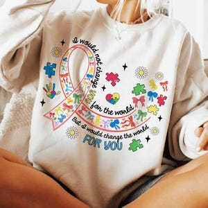 May include: White sweatshirt with a colorful ribbon design and the text "I would not change you for the world, But I would change the world FOR YOU".