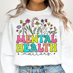 May include: White sweatshirt with a colorful floral design and the text "MENTAL HEALTH matters".