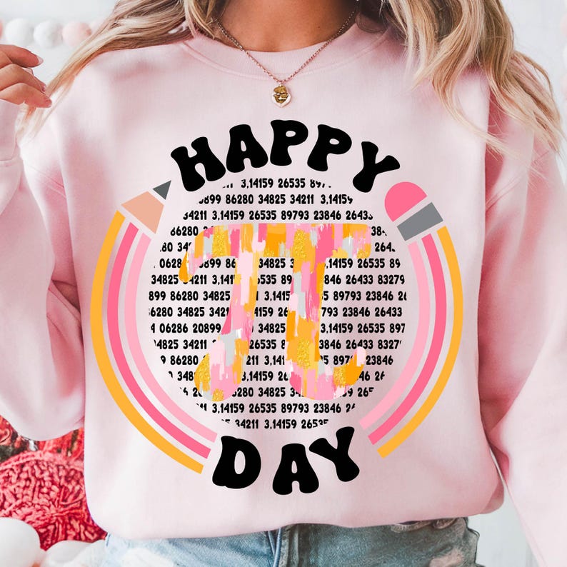May include: A pink sweatshirt with a rainbow design and the text "HAPPY DAY" in a retro font. The rainbow is made up of numbers and the text is surrounded by a yellow circle.