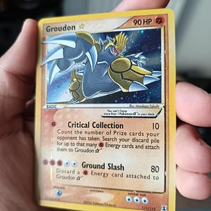 May include: A Groudon Star Pokémon trading card with 90 HP, featuring a gold-colored Groudon illustration, the Critical Collection and Ground Slash attacks, and the text 111/113, 2005 Pokémon/Nintendo, and Illus. Masakazu Fukuda printed on the card.