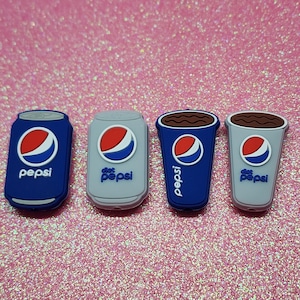 May include: Four Pepsi-themed charms in blue and gray. Two are soda cans, one labeled "Pepsi" and the other "Diet Pepsi." The other two are cups, one blue and one gray, with the Pepsi logo and the text "Pepsi" and "Diet Pepsi."