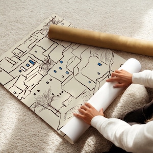 Pu&ograve; includere: Una stampa architettonica arrotolata con un design in bianco e nero con edifici e alberi, con accenti blu. Un secondo rotolo della stampa viene srotolato da una persona.