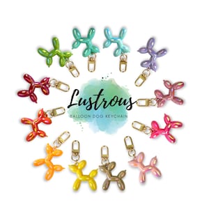 Può includere: Una collezione di dodici portachiavi a forma di cane palloncino in vari colori iridescenti, tra cui verde, blu, viola, rosso, rosa, arancione e giallo. Ogni portachiavi presenta un moschettone dorato. Il testo Lustrous BALLOON DOG KEYCHAIN è centrato.