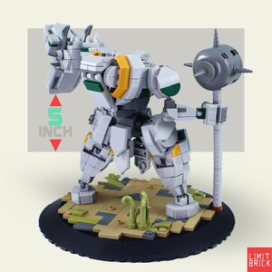Może przedstawiać: Biały, szary, zielony i ż&oacute;łty model robota, o wysokości około 13 cm, stoi na brązowo-zielonej podstawie. Robot trzyma szarą broń. Model wykonany jest z zazębiających się klock&oacute;w. Widoczny jest tekst "LIMIT BRICK".
