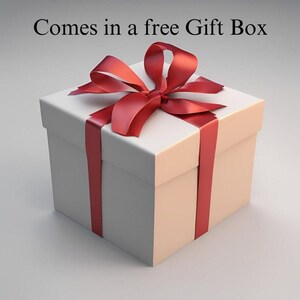 以下が含まれることがあります： 赤いリボンと蝶結びが付いた白いギフトボックス。ボックスは正方形で閉じられています。「Comes in a free Gift Box」というテキストが画像の上部にあります。