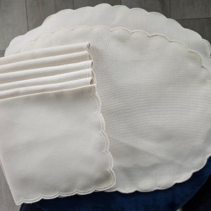 May include: Set of six off-white scalloped linen placemats with a matching scalloped linen napkin.