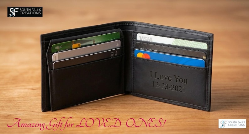 May include: Black leather wallet, open to display credit cards and a personalized message. The wallet has multiple card slots and a bill compartment. The text "I Love You 12-23-2021" is engraved on the inside.