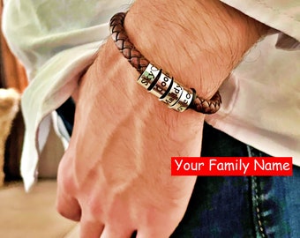 May include: A brown leather bracelet with silver metal beads engraved with the names "Leo", "Maddy", "Dood", and "Sky".